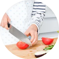 包丁でトマトを切っている手元